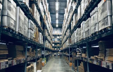 High-bay warehouse aisle where Petlland consolidates pet product orders