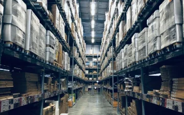 High-bay warehouse aisle where Petlland consolidates pet product orders