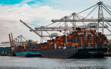 Container ship loaded with freight leaving port representing distributor volume shipments