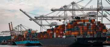 Container ship loaded with freight leaving port representing distributor volume shipments Container ship loaded with freight leaving port representing distributor volume shipments