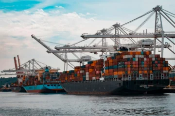 Container ship loaded with freight leaving port representing distributor volume shipments